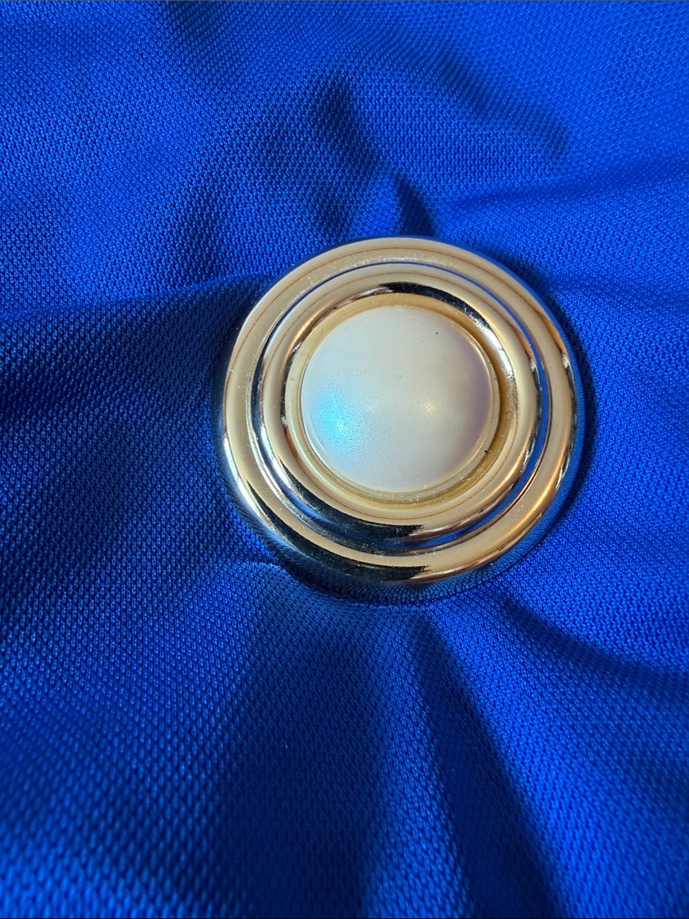 Gold Metal Ring Button Accent on Royal Blue Fabric